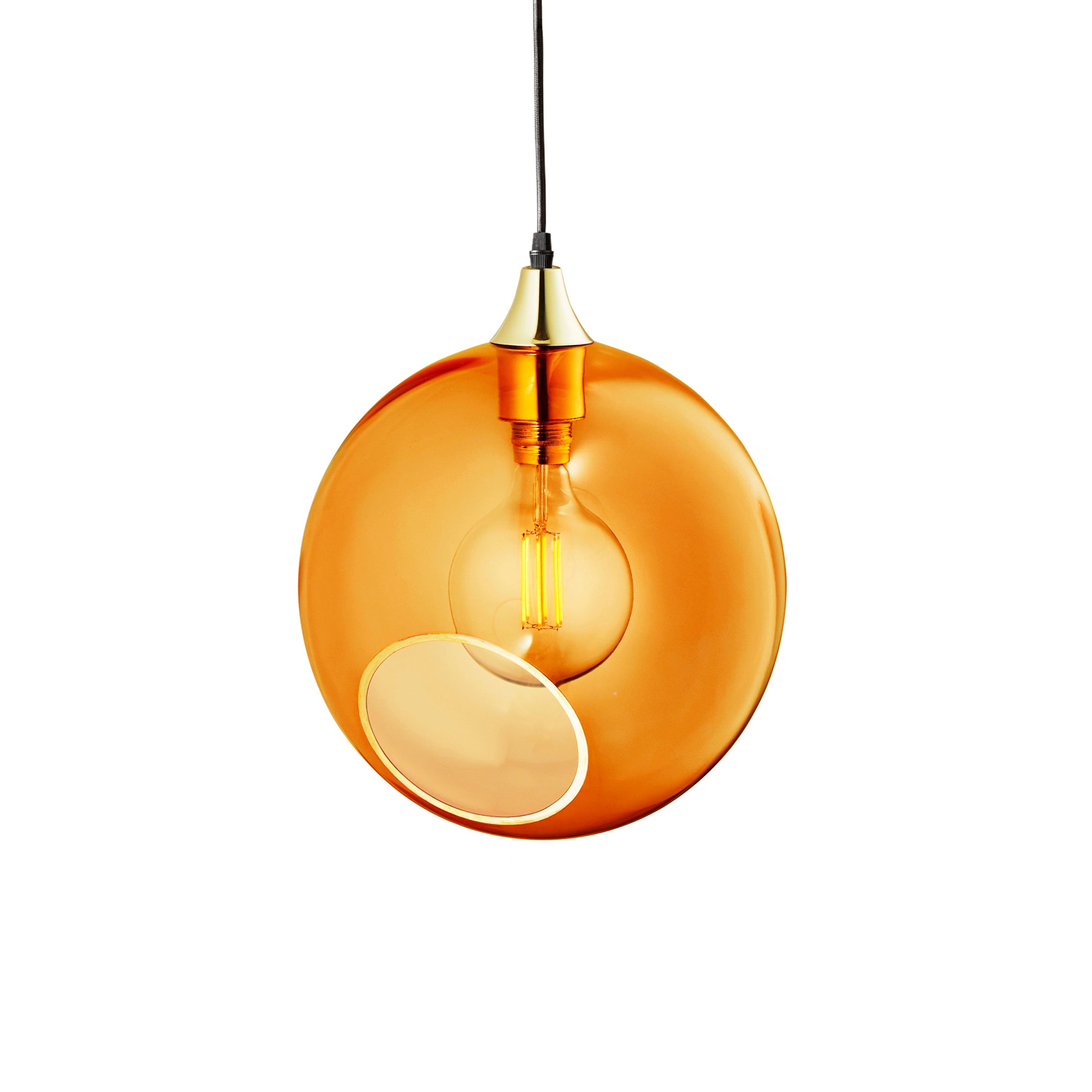 Rund lampa i orange/gult glas och med en avskuren bit med guldkant som ger en skymt av glödlampan. Sockeln och rosetten är guldfärgade och kabeln av svart textil.