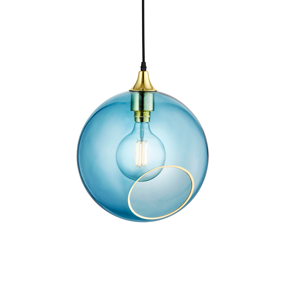 Rund lampa i blått glas och med en avskuren bit med guldkant för en skymt av glödlampan. Sockeln och rosetten är guldfärgade och kabeln av svart textil.