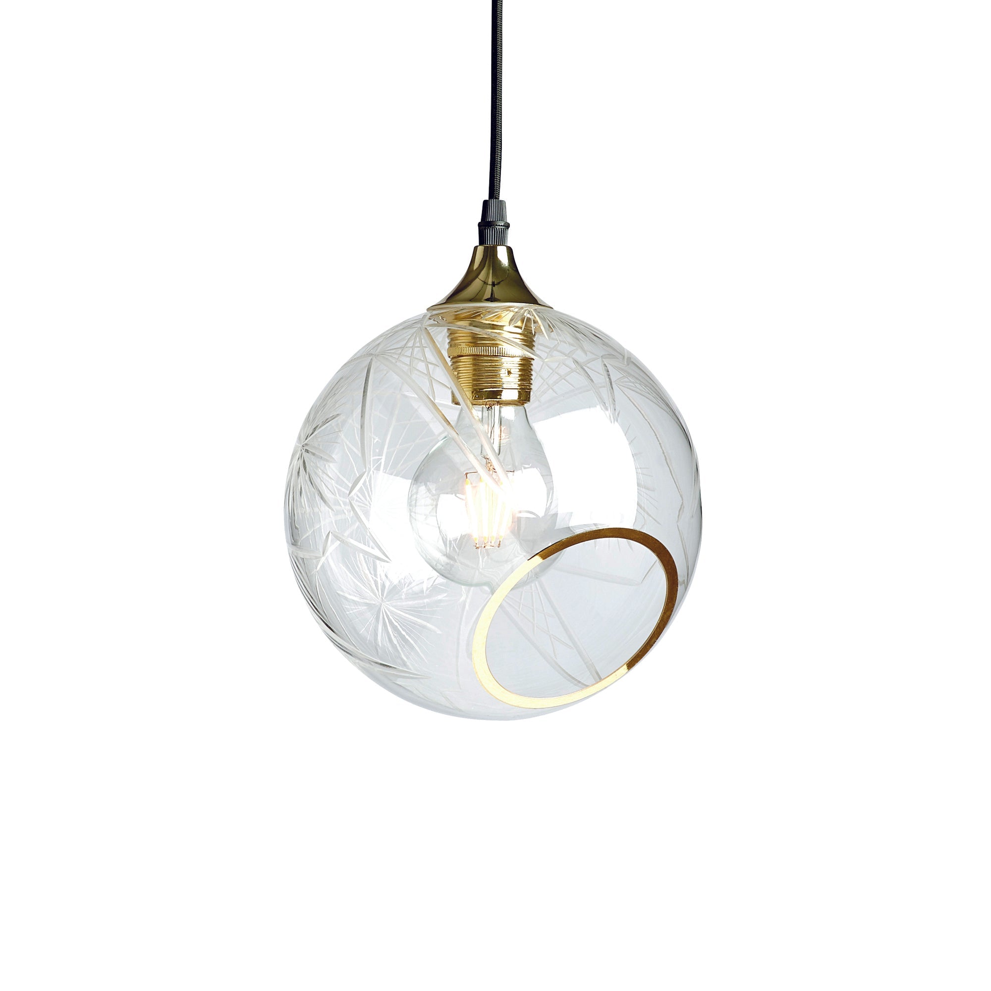 Rund lampa i klarglas med diamond cut-mönster och med en skuren bit med guldkant som ger en skymt av glödlampan. Sockel och rosett är guldfärgade och sladden är av svart tyg.