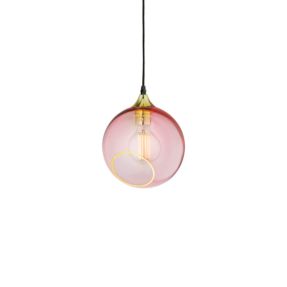Rund lampa i rosafärgat glas med en avskuren bit med guldkant. Sockeln är guldfärgad och kabeln av svart textil.