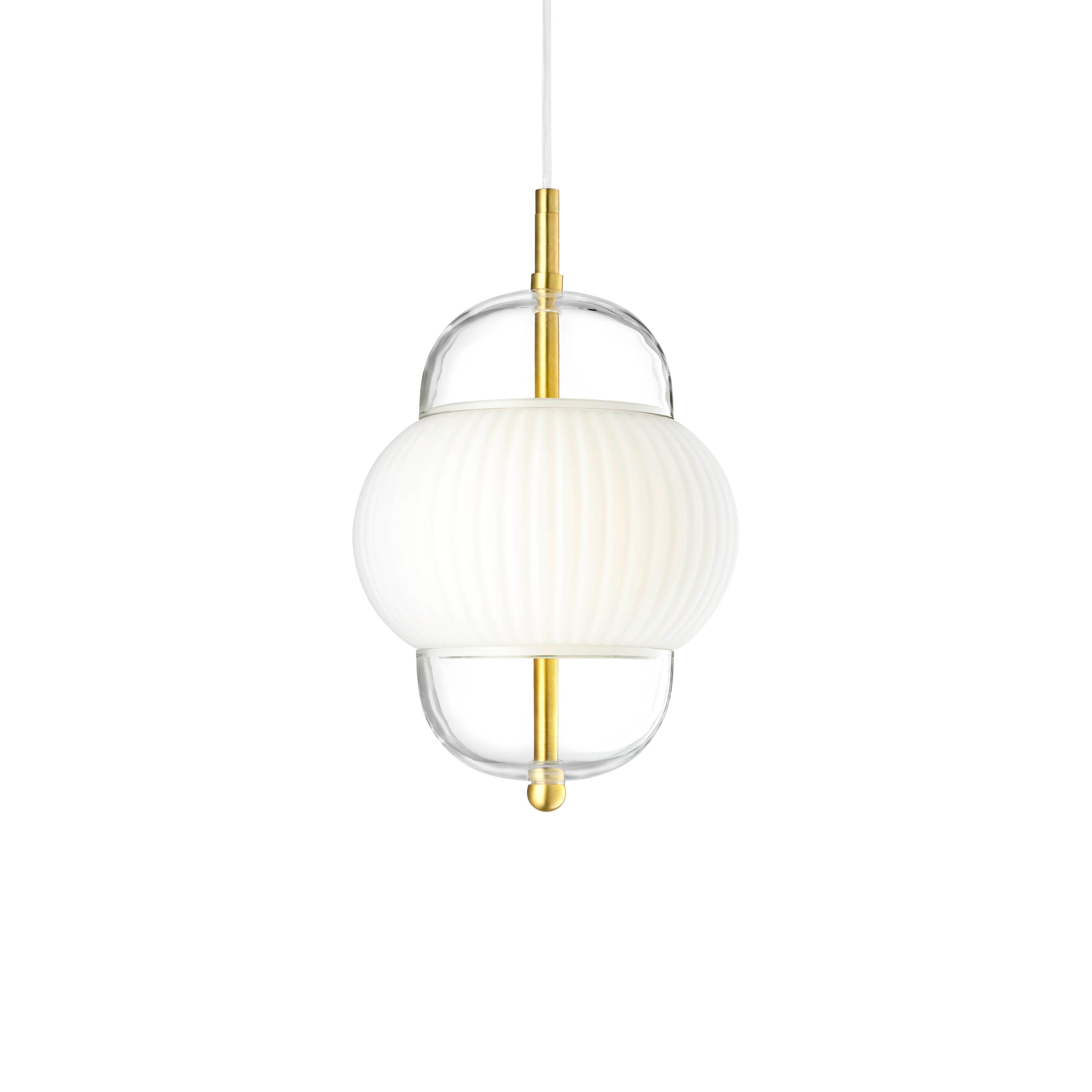 Lampa i klarglas och matt vitt veckat glas. Dessutom har lampan detaljer i mässing och en vit textilkabel.
