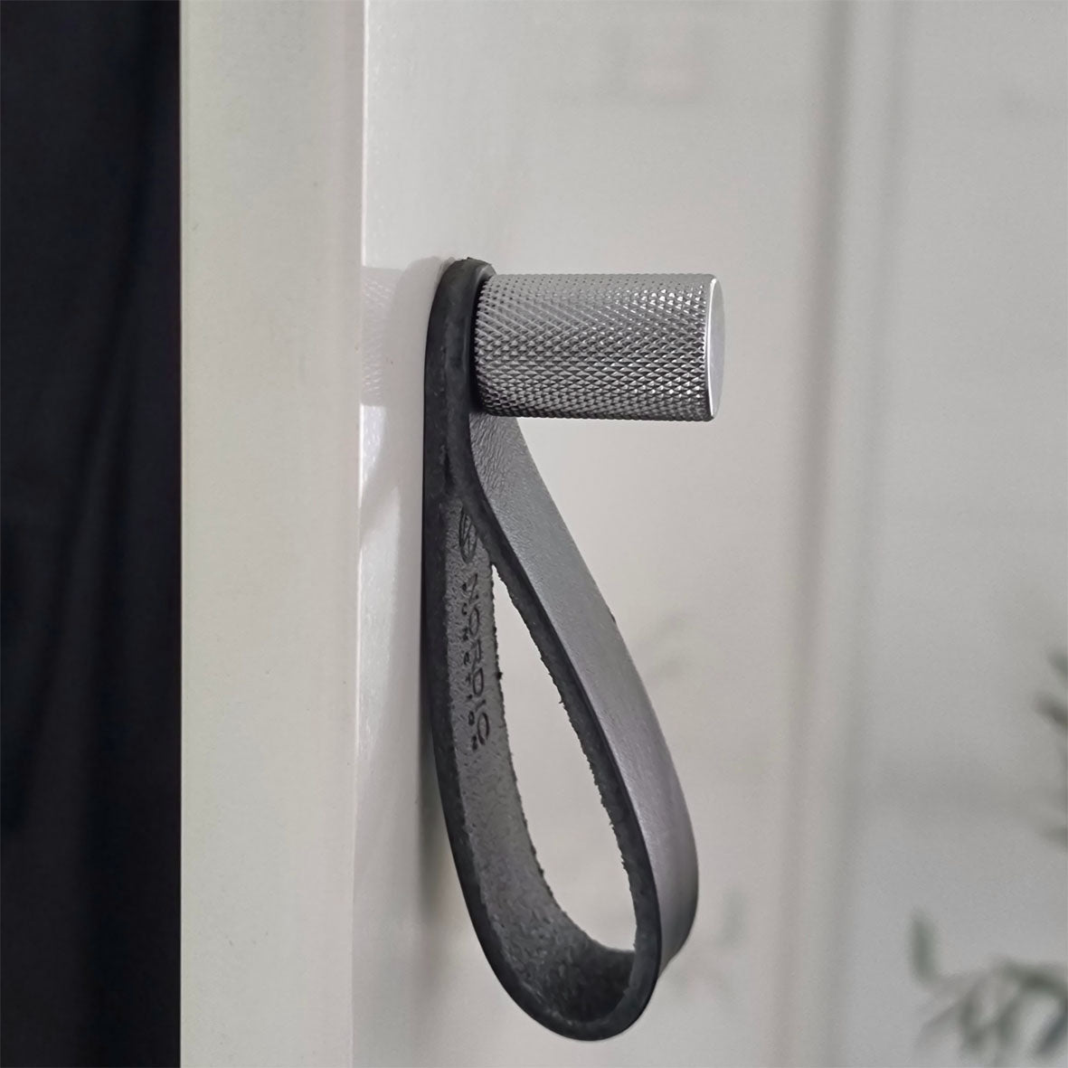 Två krokar i krom med diamond cut-mönster samt en svart läderögla