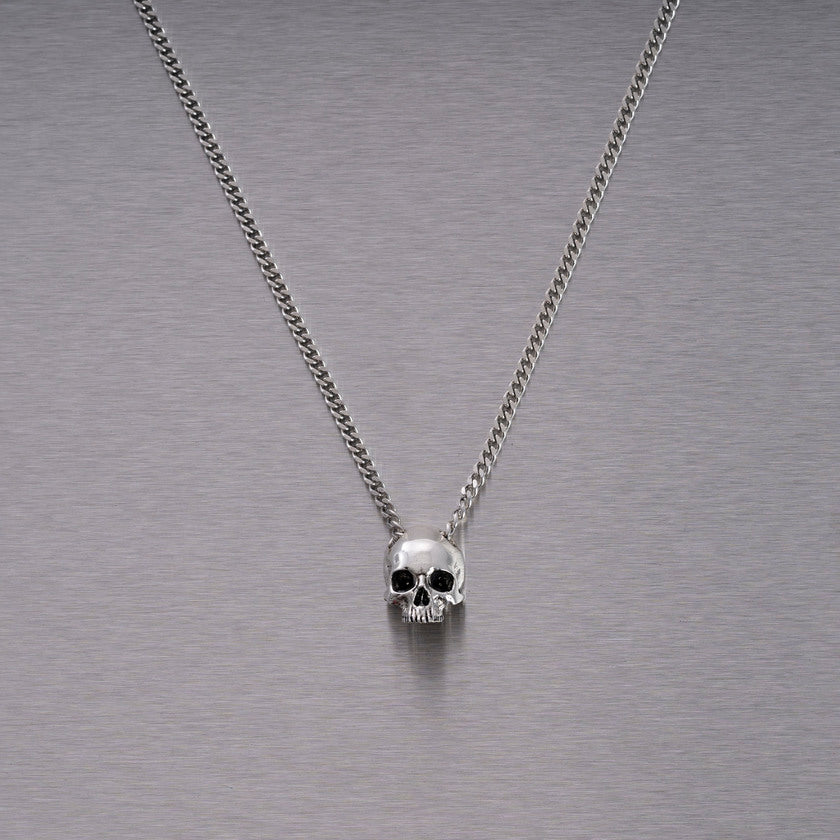 Halsband med ett hänge i form av en dödskalle, i silver.