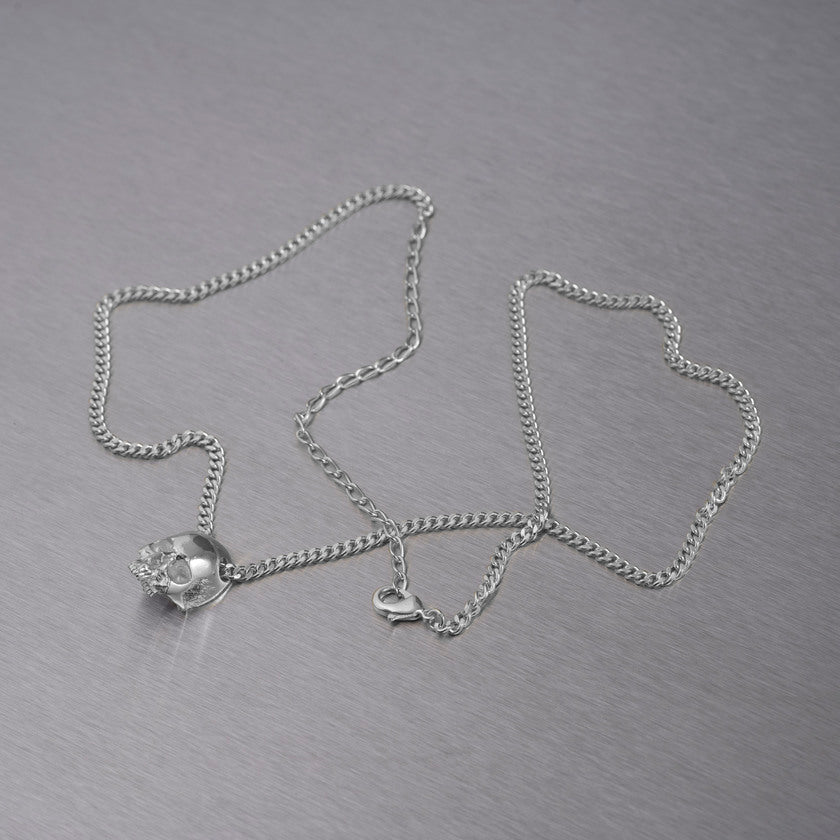 Halsband med ett hänge i form av en dödskalle, i silver.