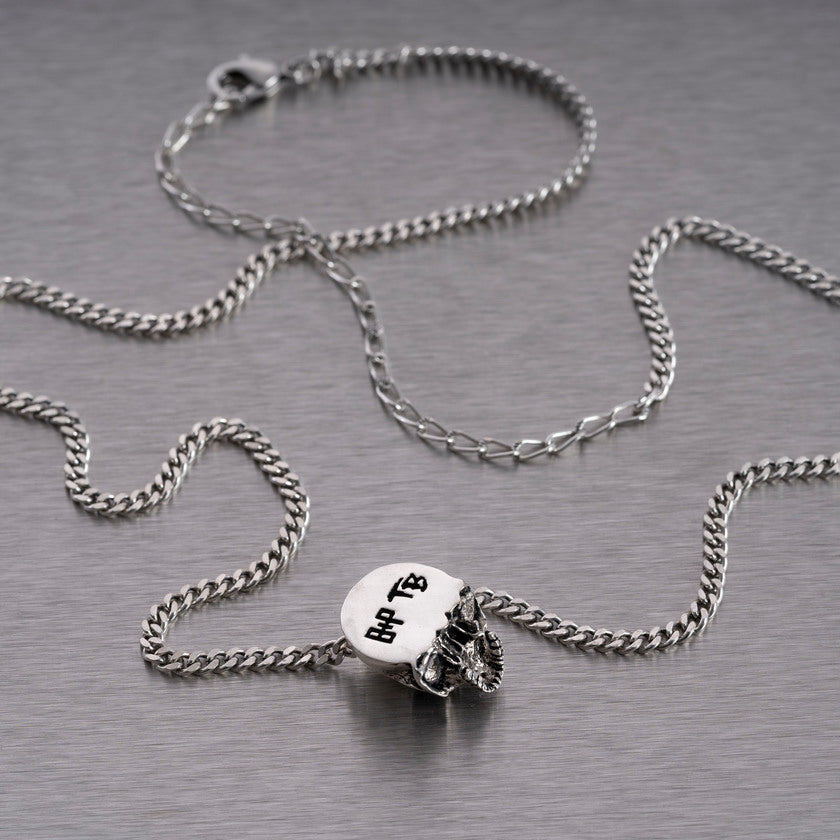 Halsband med ett hänge i form av en dödskalle, i silver.