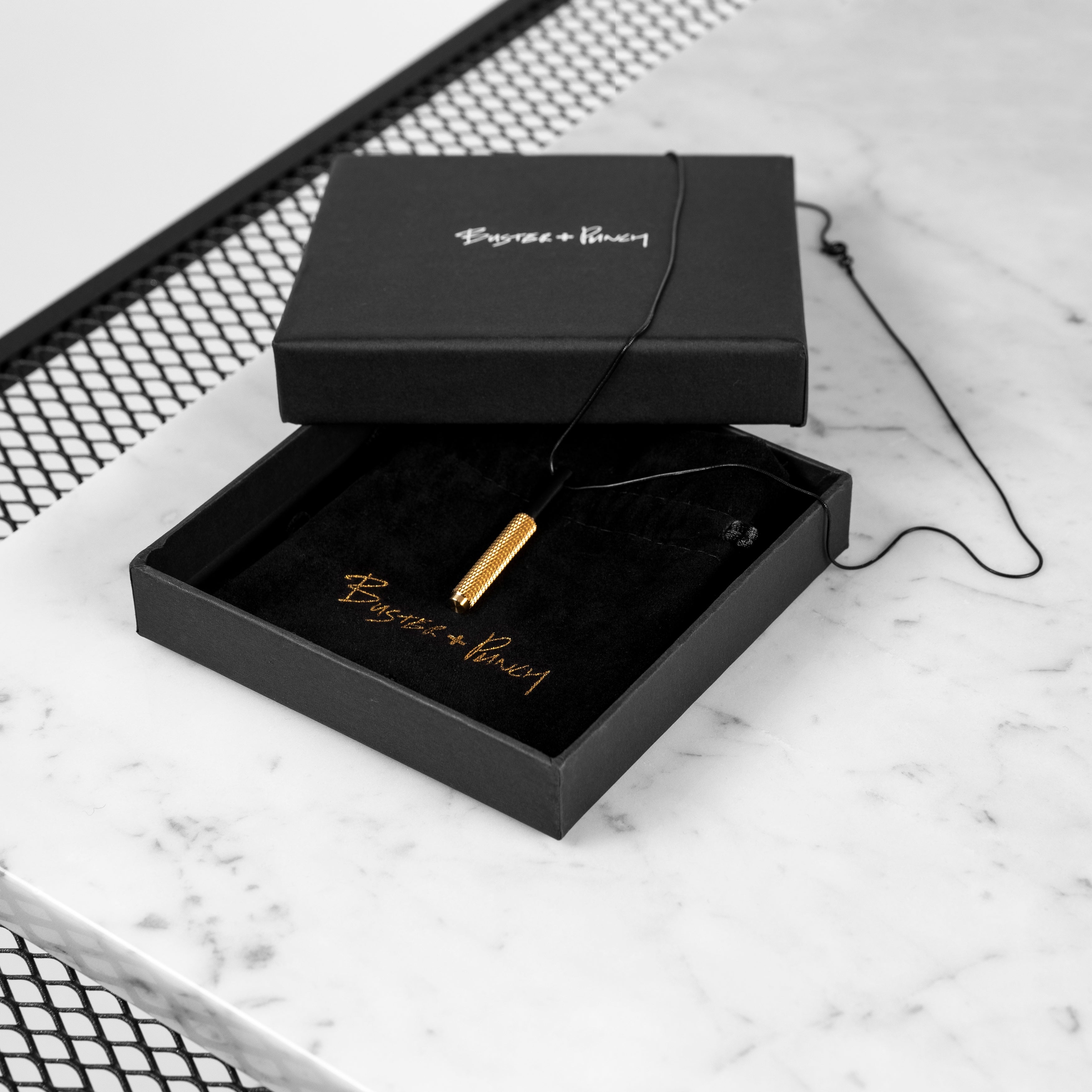 Halsband i svart med hänge i svart och mässing. Mässingsdelen av hänget är dekorerat med det populära diamantslipade mönstret.