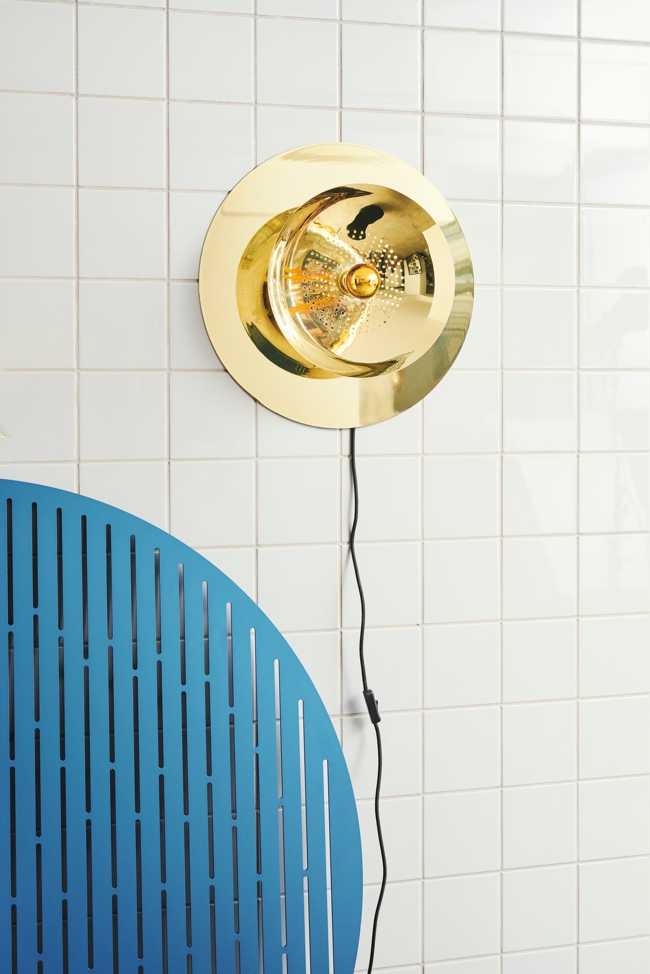 Wanted Wall vägglampa med fästplatta mot en vägg med vitt kakel.