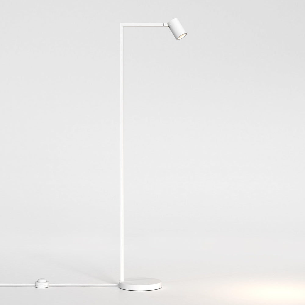 Vit golvlampa med justerbart huvud. Lampan har en enkel design med kantiga linjer/vinklar.
