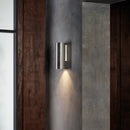 Utomhuslampa i rostfritt stål med en avlång, rundad design. Lampan har ett nedåtriktat konformat ljus.