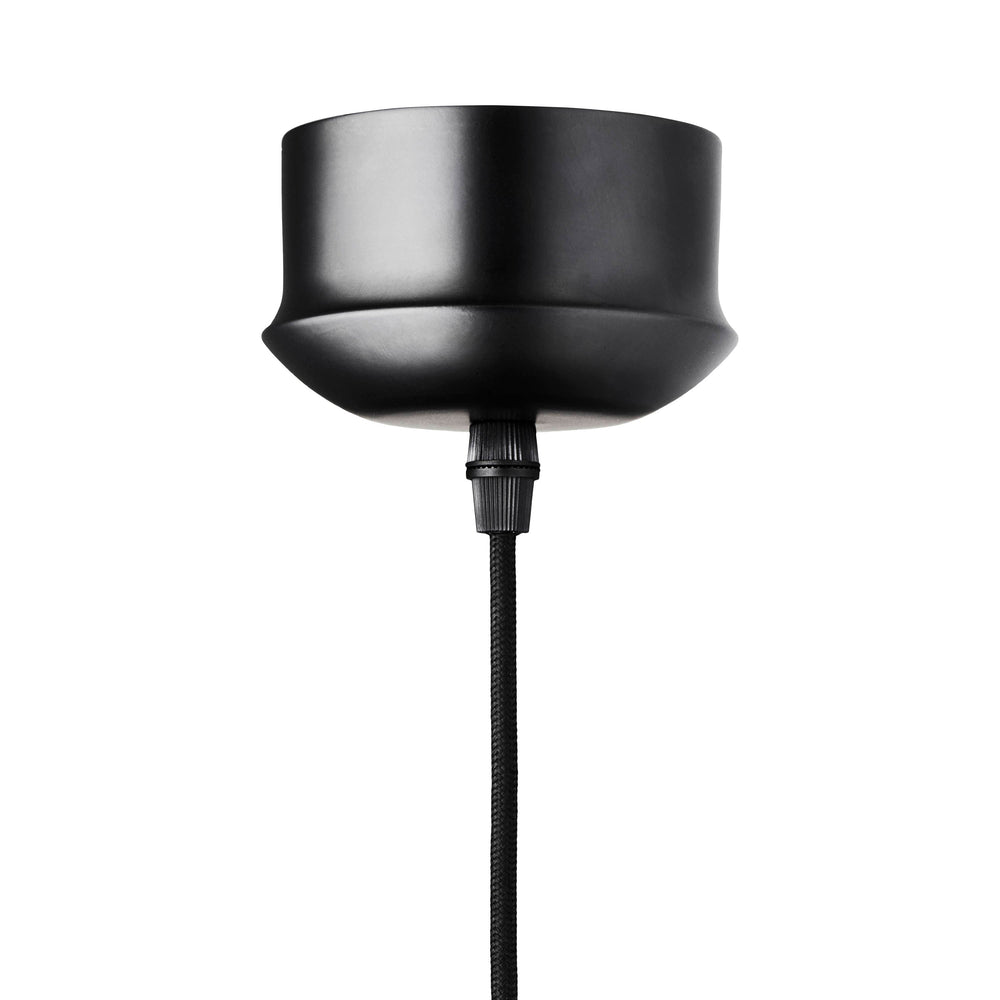 Rund lampa i grönt glas med en avskuren bit som ger en skymt av glödlampan. Sockeln är svart och kabeln av svart textil.