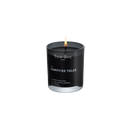 Doftljus av svart vax i rökfärgat glas med tänd låga, mot vit bakgrund.