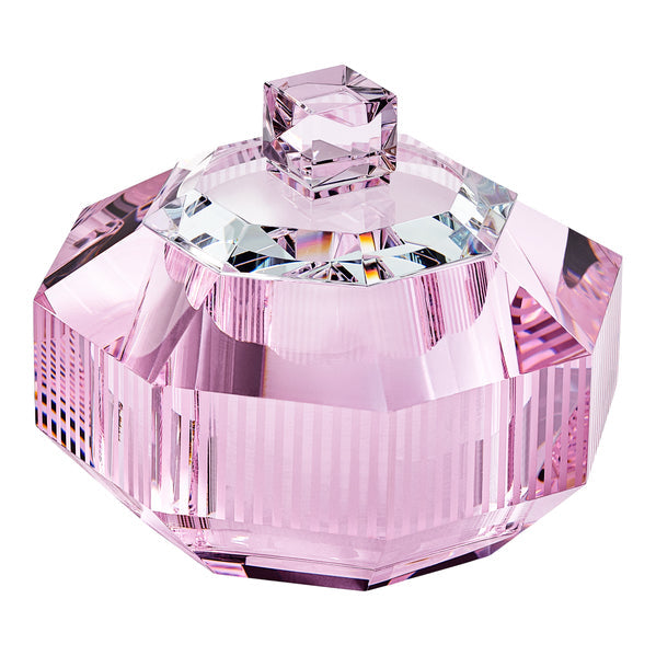 Doftljus i behållare av rosa kristall mot vit bakgrund