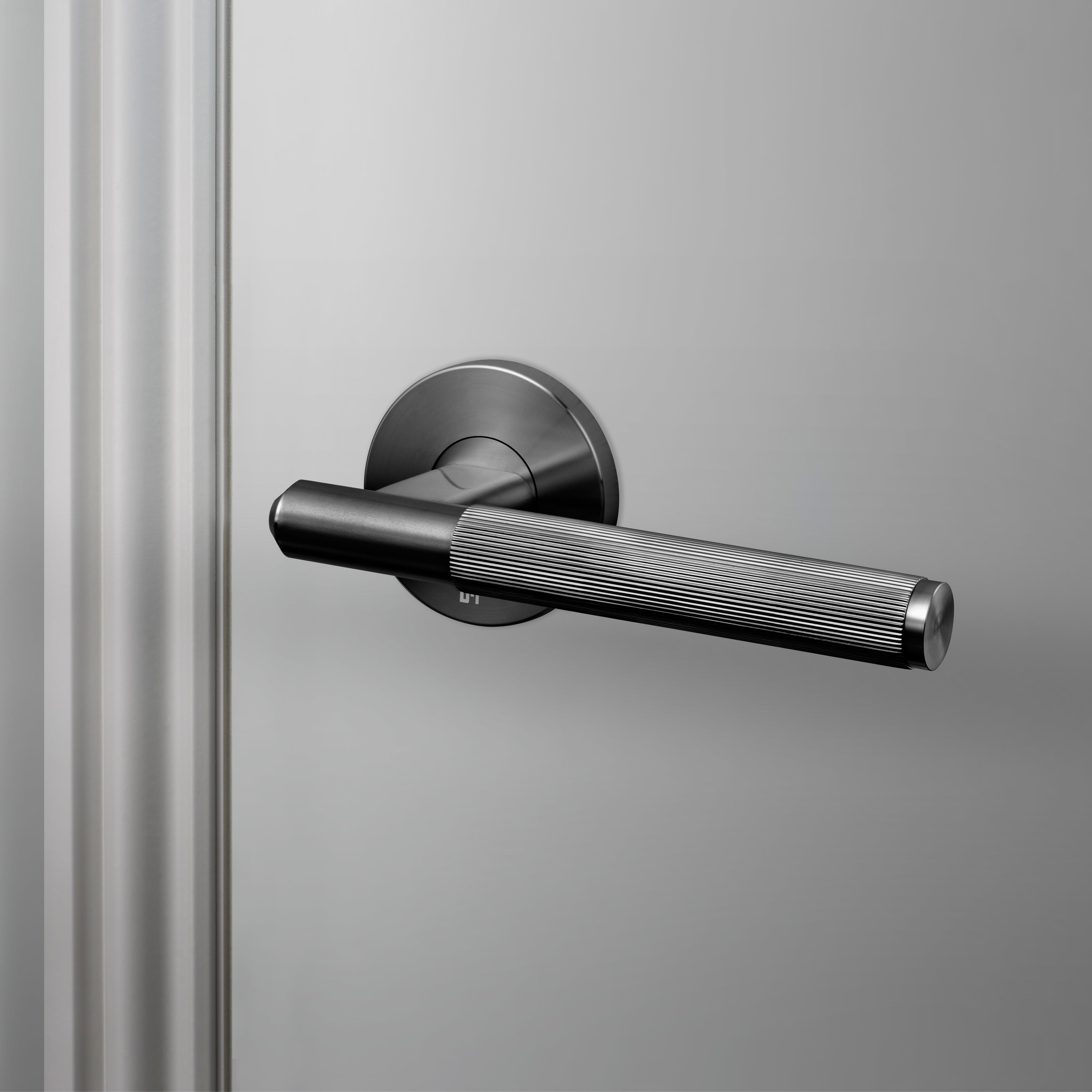 Dörrhandtag i gun metal i en rå design med linjerat mönster.