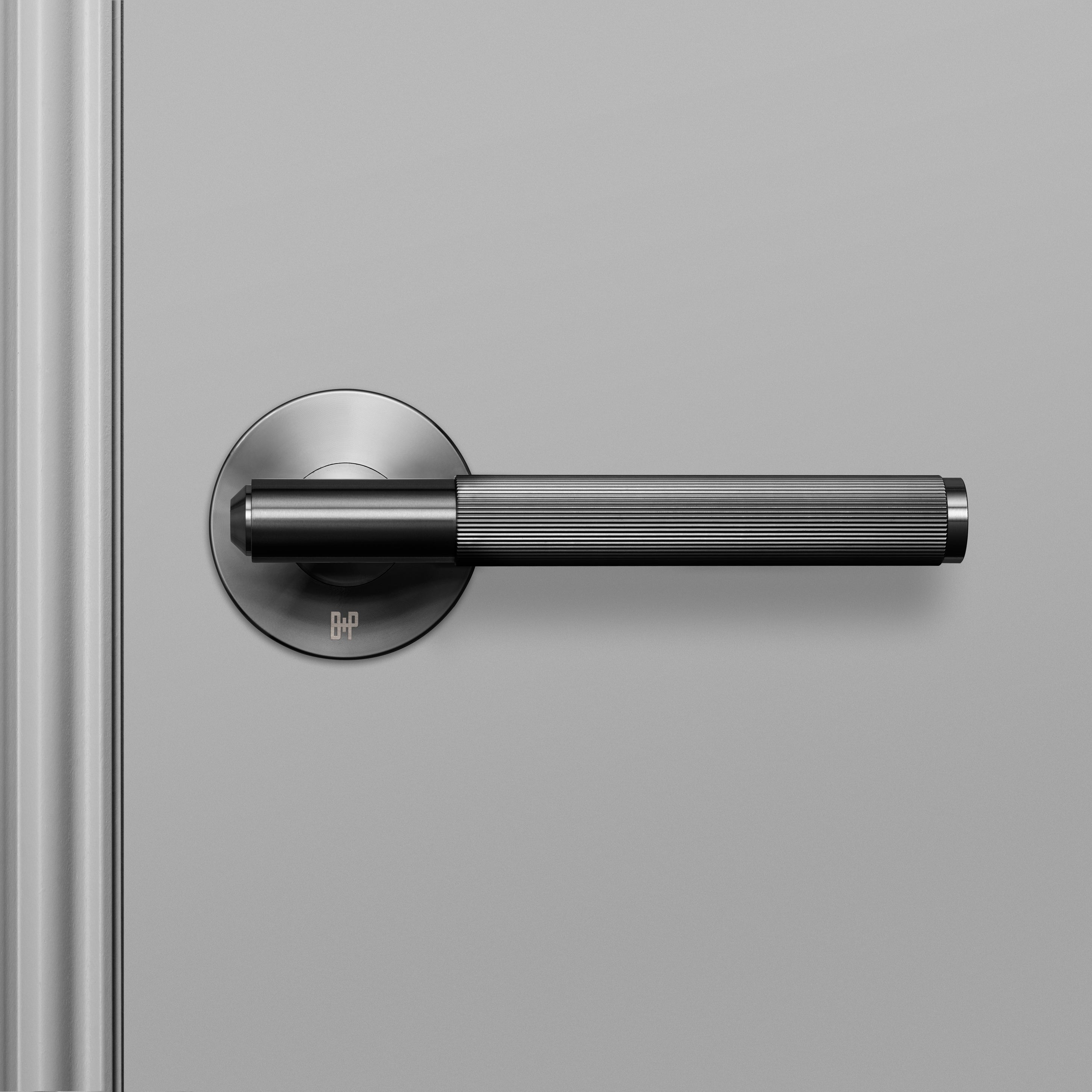 Dörrhandtag i gun metal i en rå design med linjerat mönster.
