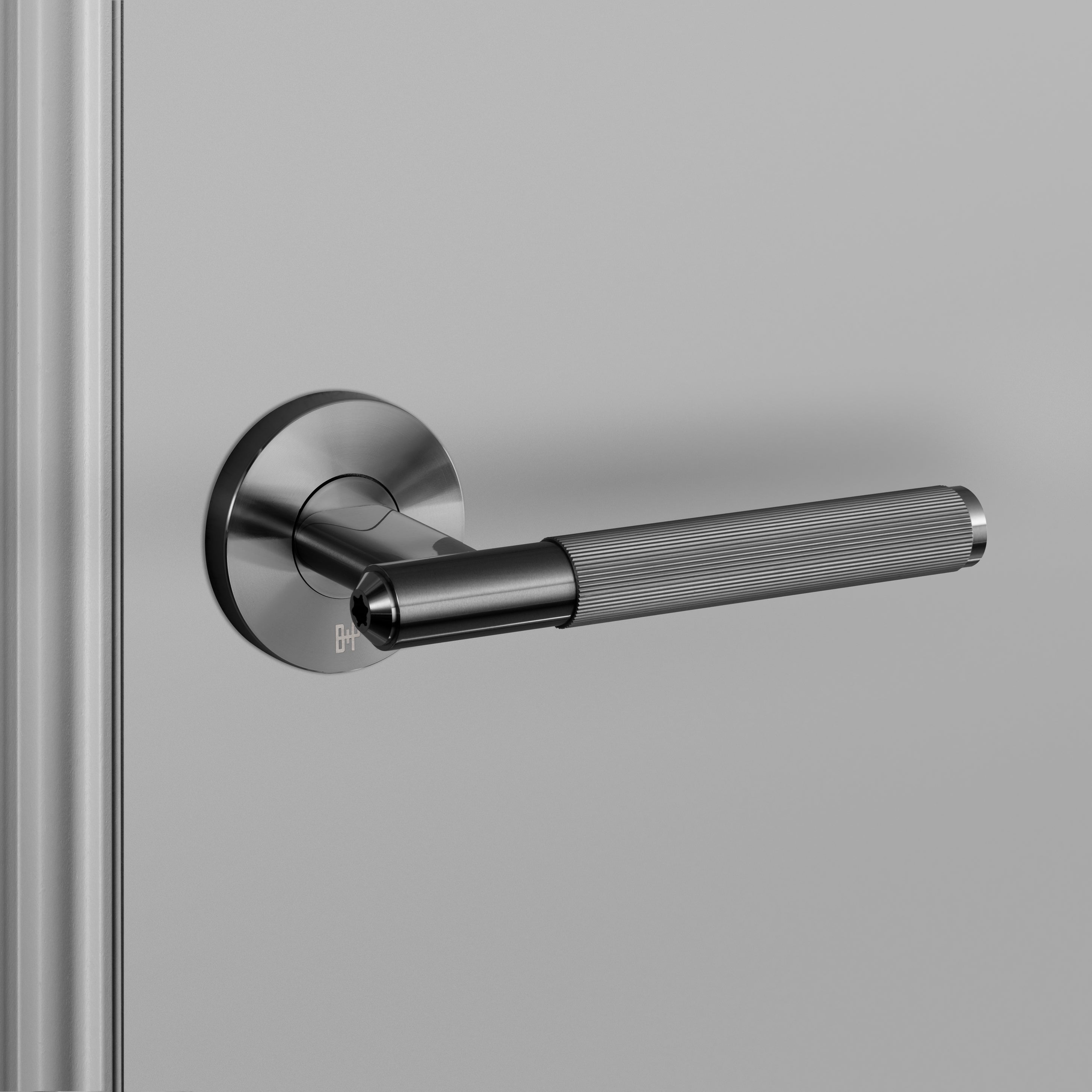 Dörrhandtag i gun metal i en rå design med linjerat mönster.