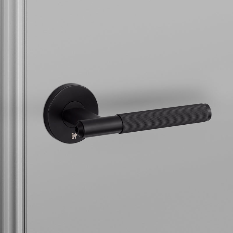 Exklusivt dörrhandtag i svart med linjerat mönster och en liten Buster + Punch-logotyp.