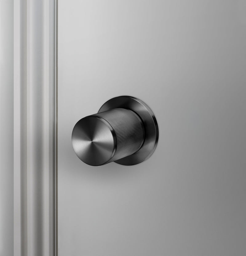 Exklusiv dörrknopp i gun metal med linjerat mönster.