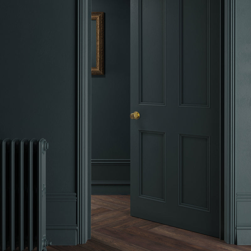 Exklusivt dörrknopp i mässing med linjerad design. Här visas dörrknoppen monterad på en grön dörr.