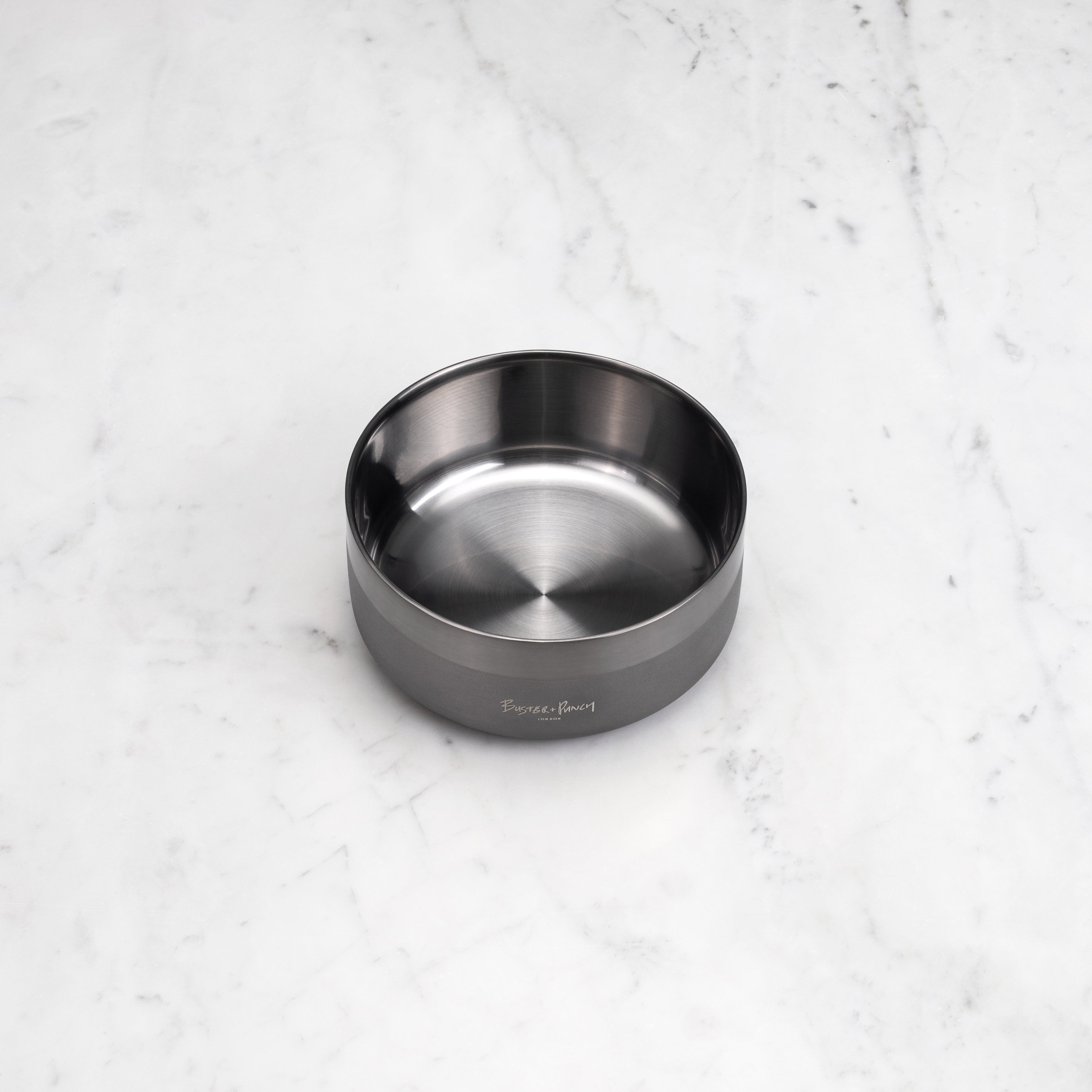 Hundskål i stål med gun metal-finish på ett marmorbord