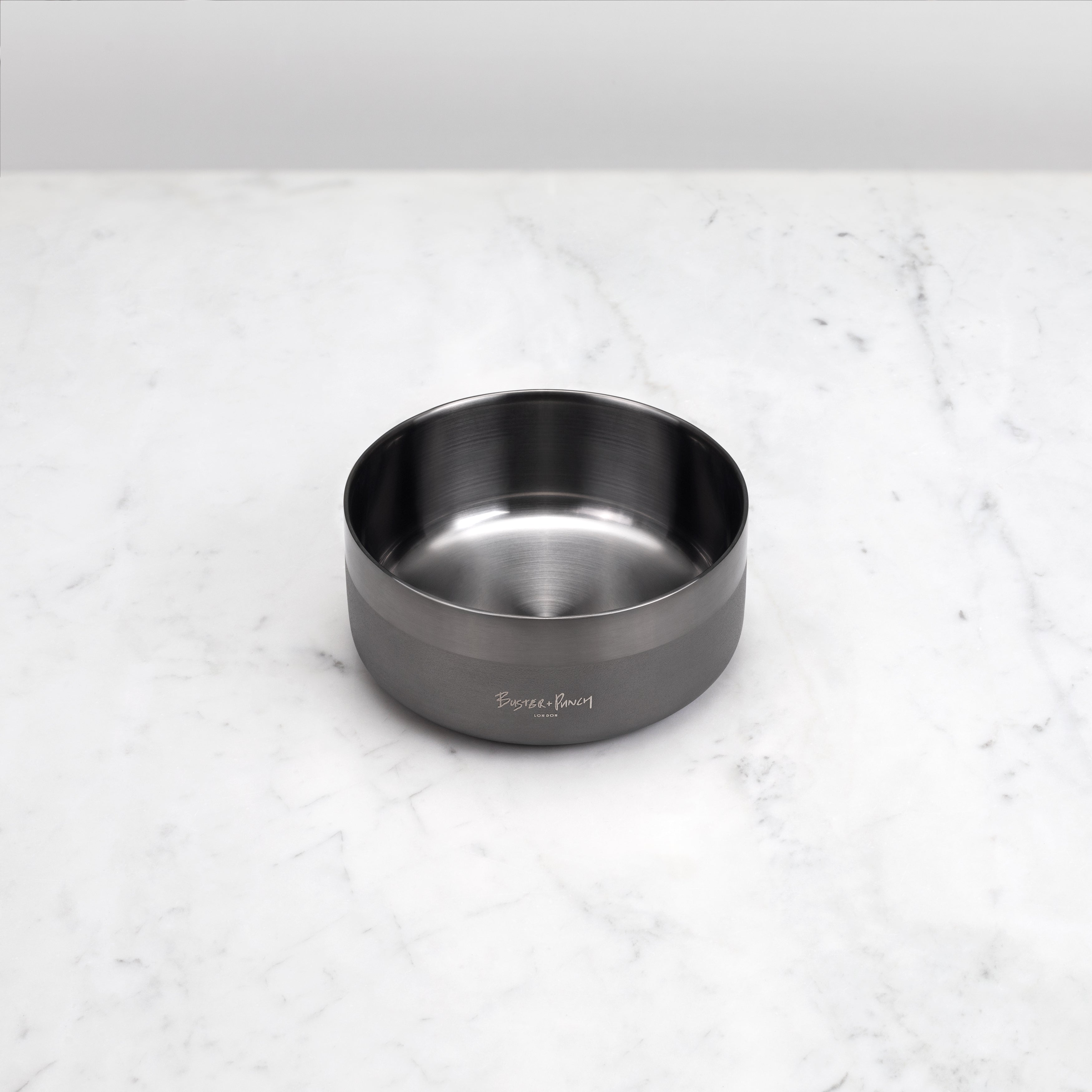 Hundskål i stål med gun metal-finish på ett marmorbord
