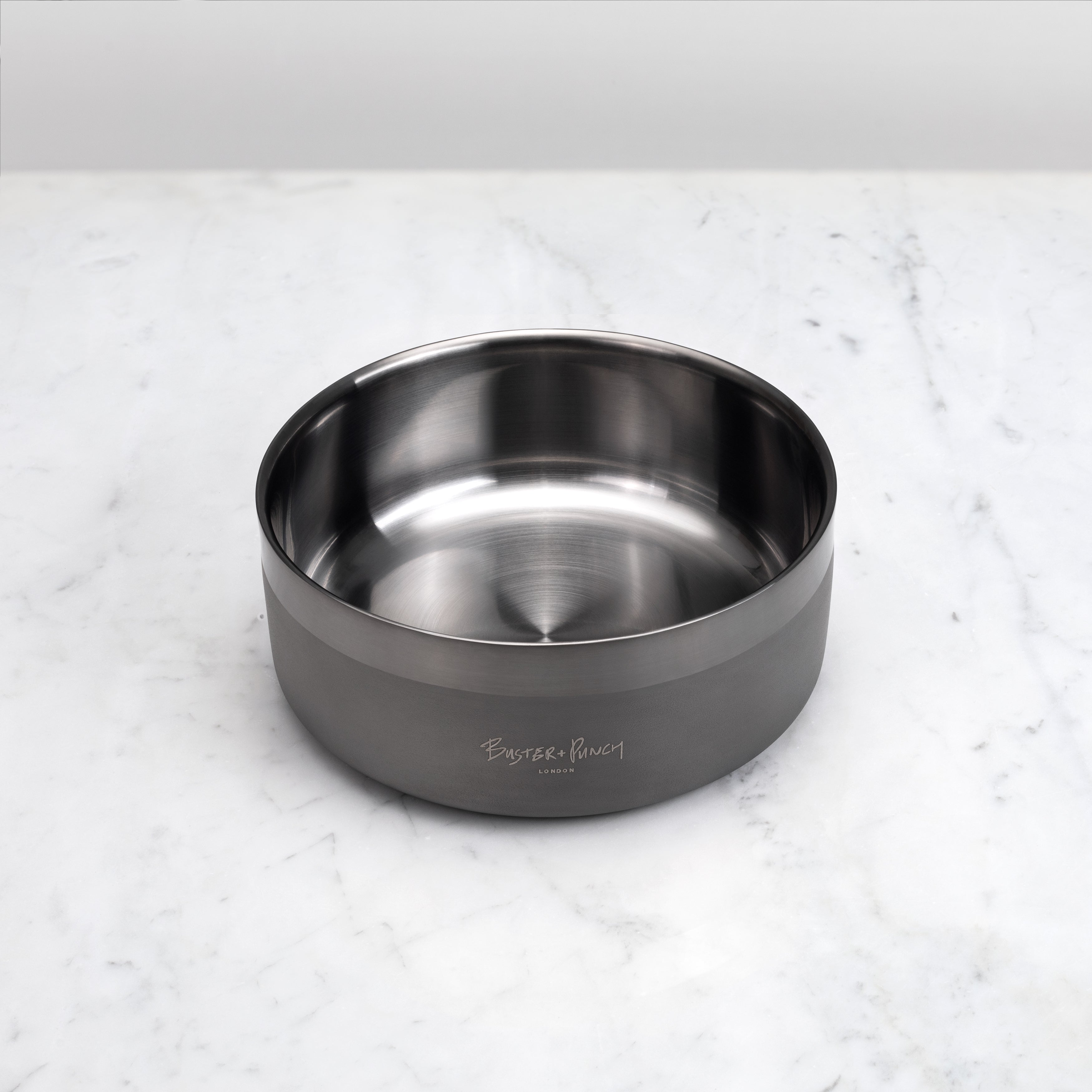 Hundskål i stål med gun metal-finish på ett marmorbord