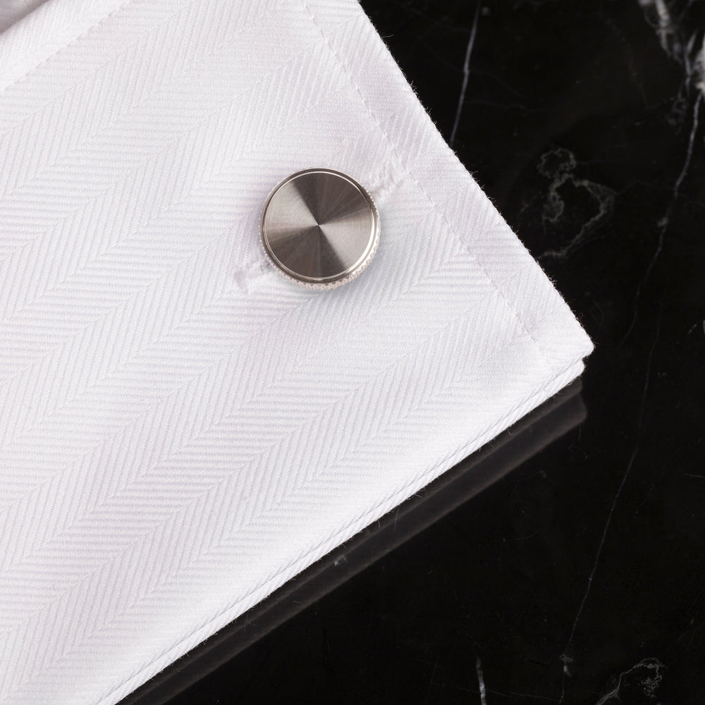 2 st. manschettknappar av stål. Kanten på knappen är dekorerad med det räfflade diamantslipade mönstret.