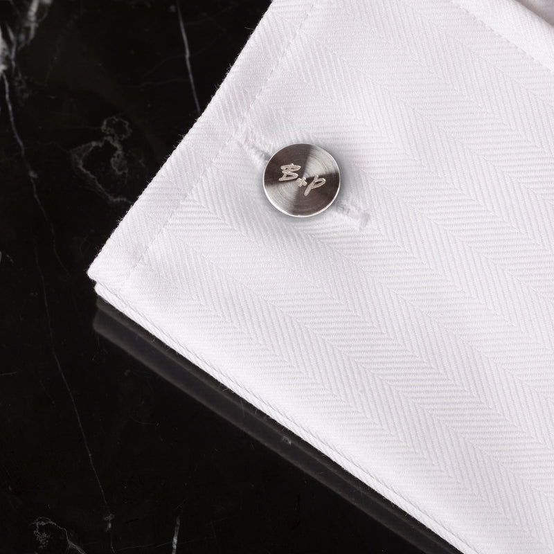 2 st. manschettknappar av stål. Kanten på knappen är dekorerad med det räfflade diamantslipade mönstret.
