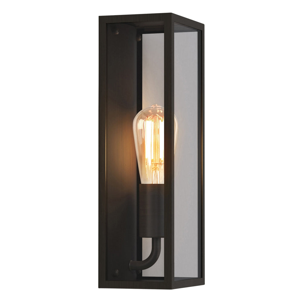 Avlång utomhuslampa med bronsfärgad stålram, glassidor och kantig form. Visas här med en glödlampa med synliga glödtrådar.