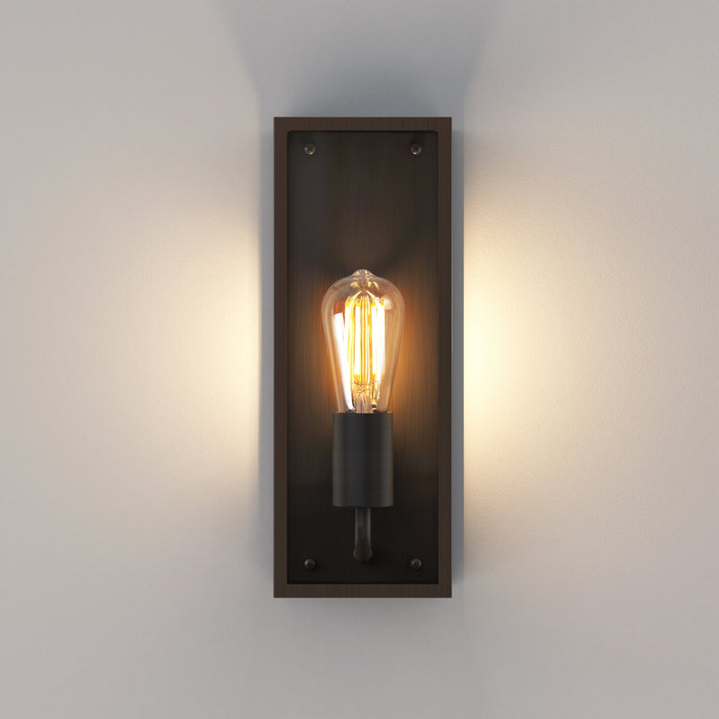 Avlång utomhuslampa med bronsfärgad stålram, glassidor och kantig form. Visas här med en glödlampa med synliga glödtrådar.