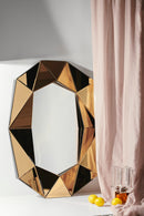 Spegel och vas i klar och bärnstensfärgad kristall stående på ett vitt golv med rosa gardin.