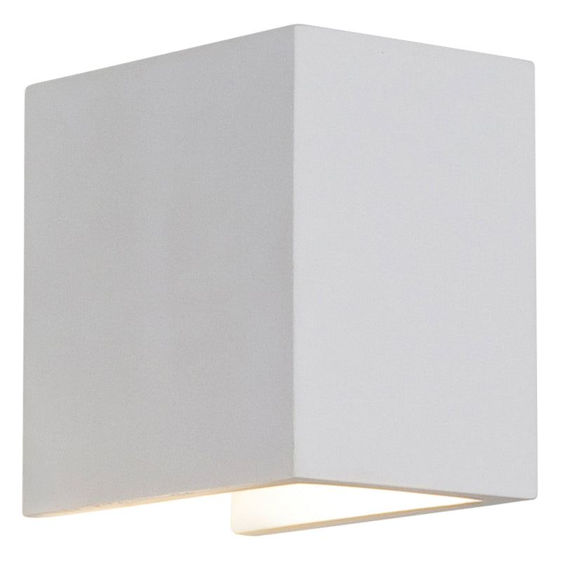 En liten vit, enkel vägglampa med kantig form tillverkad av gips. Med nedåtriktat ljus.