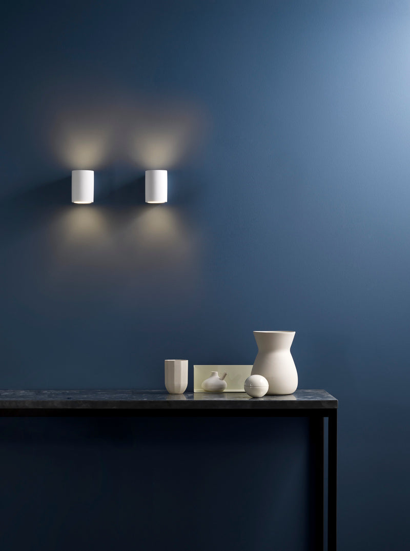 Enkel och elegant vägglampa med runda och mjuka former. Lampan har både nedåt- och uppåtriktat ljus.