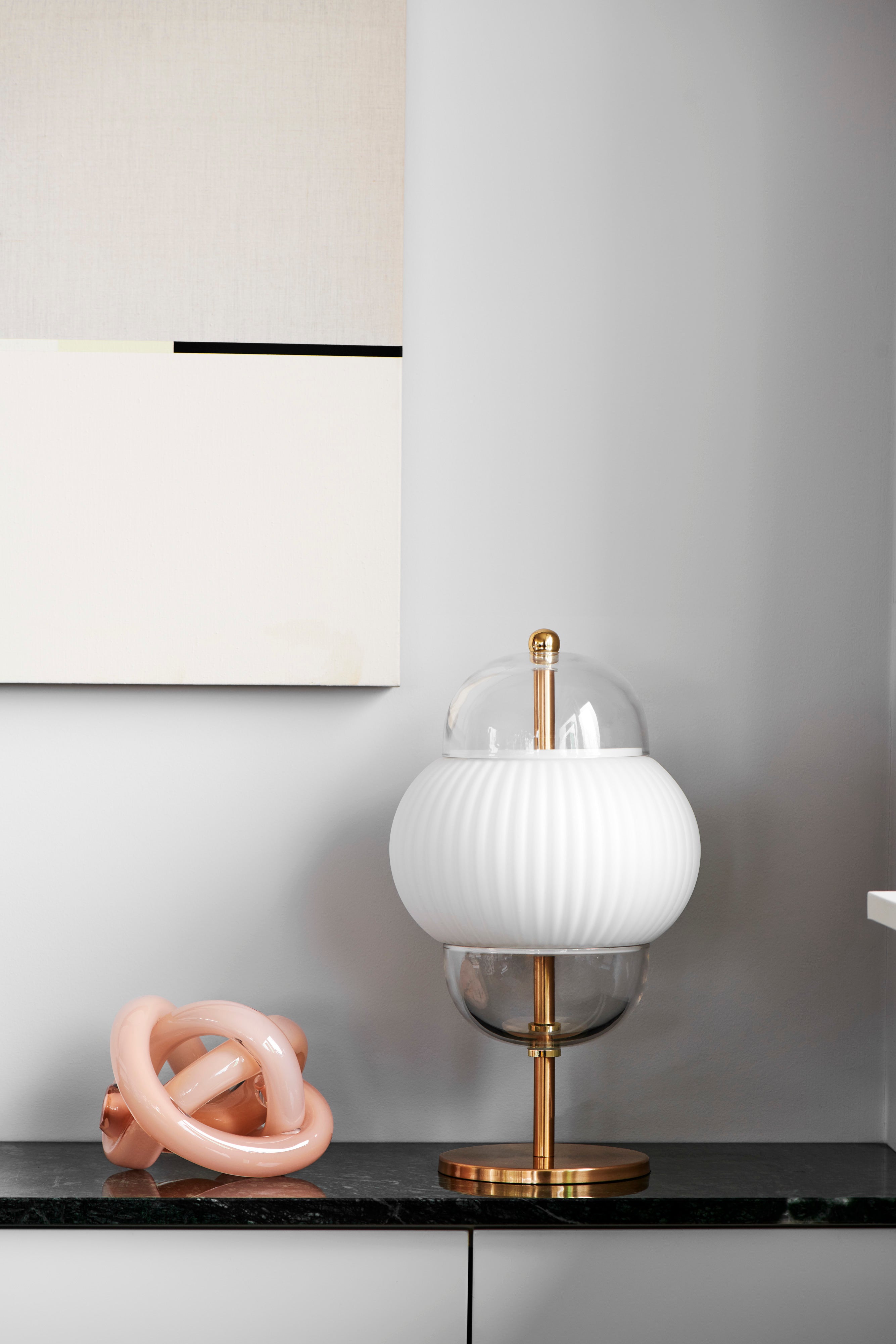 Bordslampa i klarglas och matt vitt veckat glas. Dessutom har lampan guldfärgade detaljer och fot.
