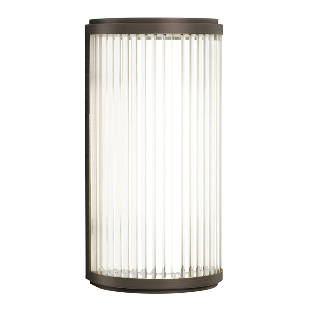 Lampa med topp, botten och baksida i bronsfärgat stål och en glasskärm med nedåtgående linjer.