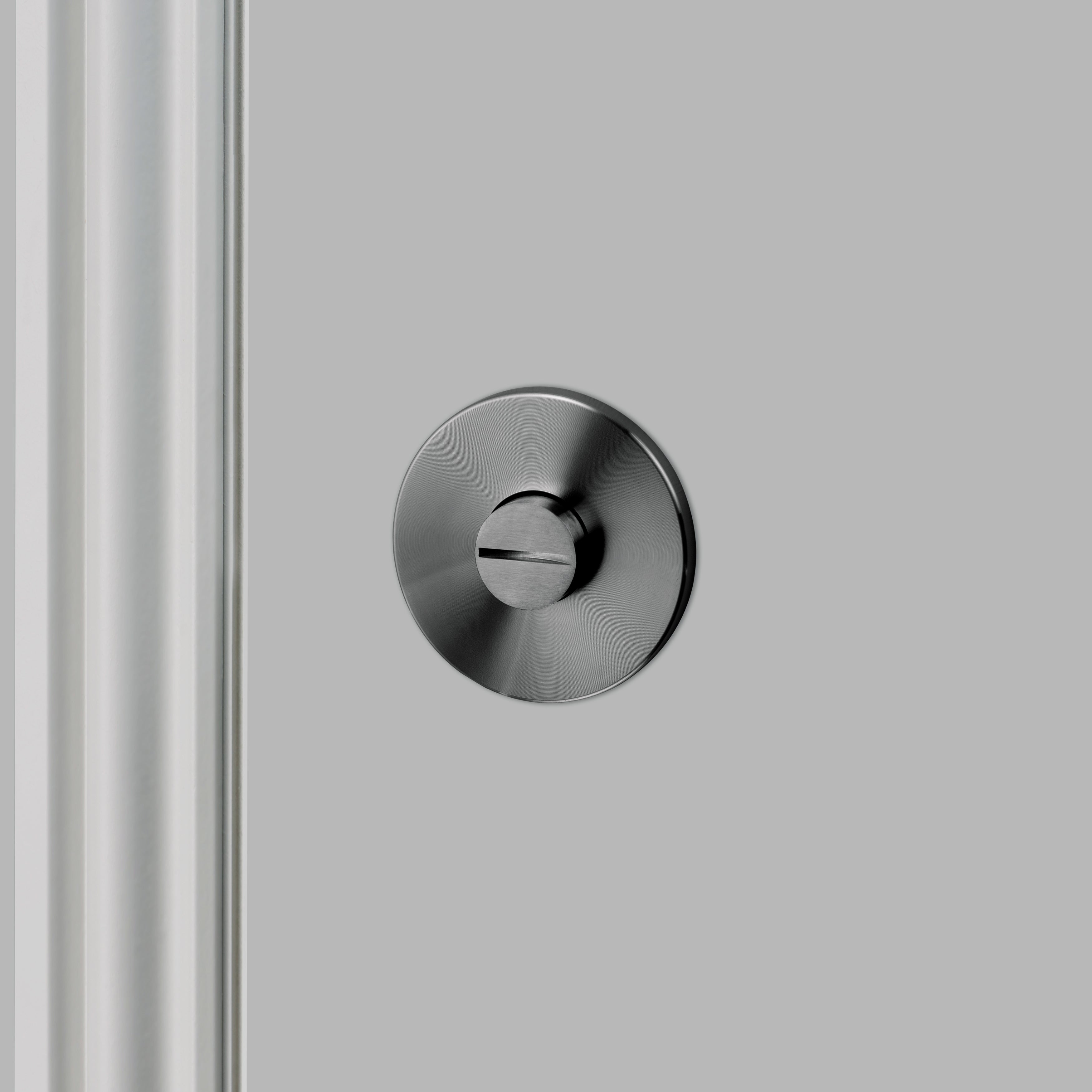 Låsvred i gun metal i exklusiv design med linjerat mönster. Här visas baksidan av låsvredet.